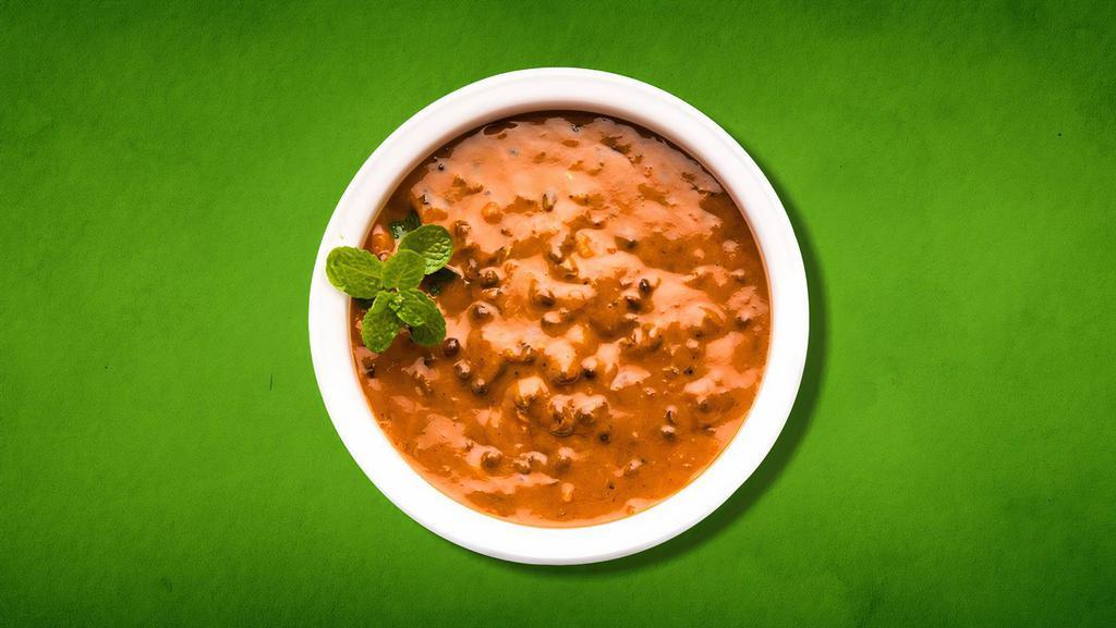Divine Daal Black(Vegan) · An aromatic blend of black lentil shimmered on a slow fire until tender, tempered with ginger, garlic, cream, and tomato sauce garnished with cilantro.