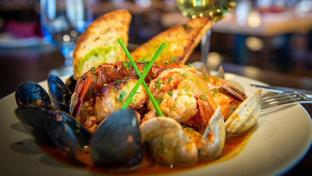 Cacciuco Tuscan Seafood Stew · Gulf shrimp, mussels, clams, calamari, sea scallops, lobster tail, catch of the day, white wine tomato broth, char-grilled Italian bread